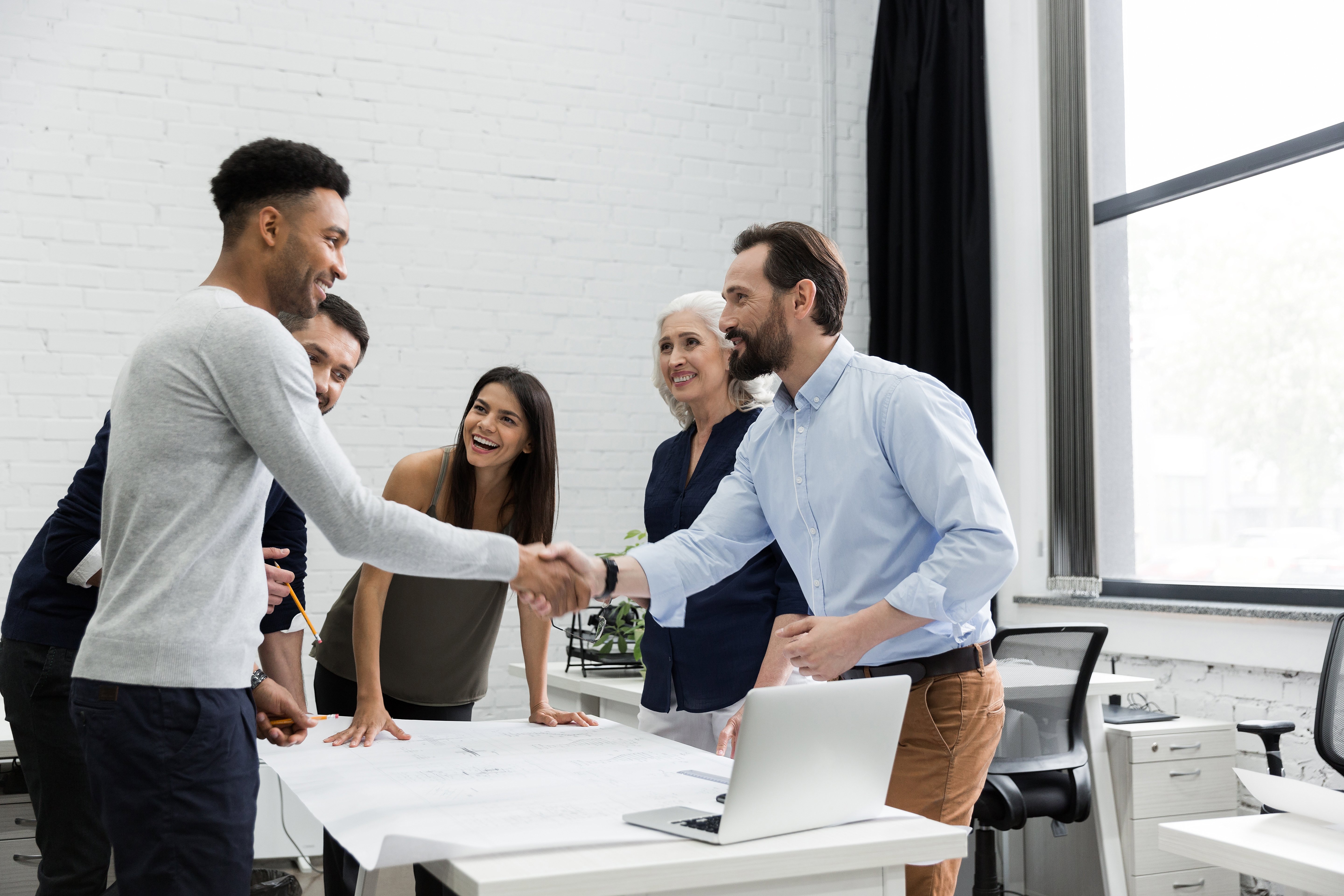 two-male-executives-shaking-hands-PHKKLRB